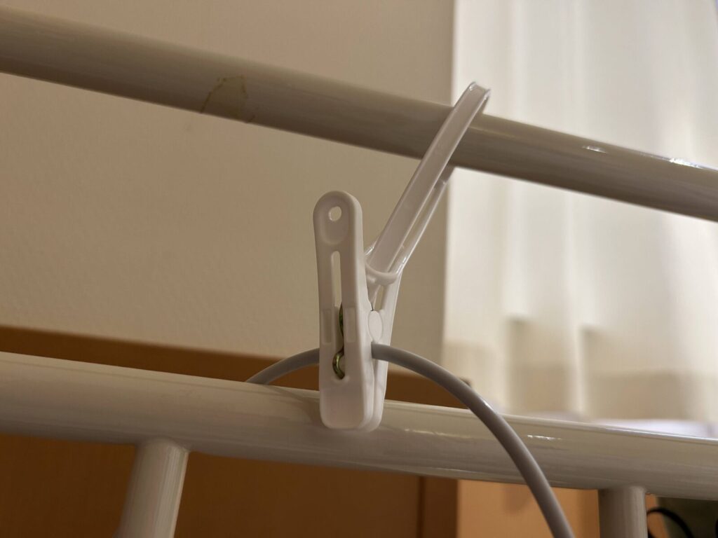 スマホの充電コードをベッドに釣っている様子